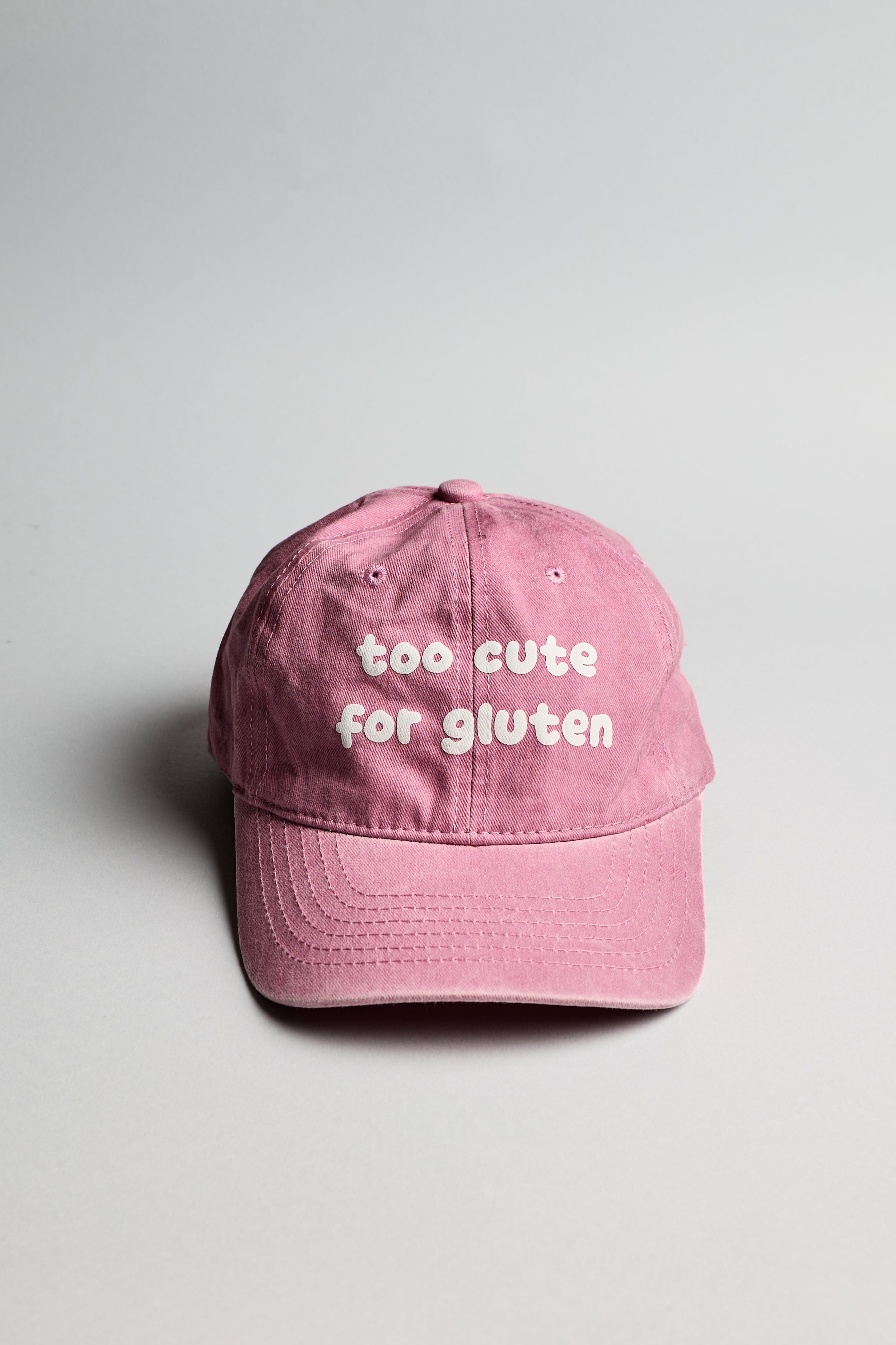 Růžová kšiltovka s bílým nápisem "too cute for gluten"