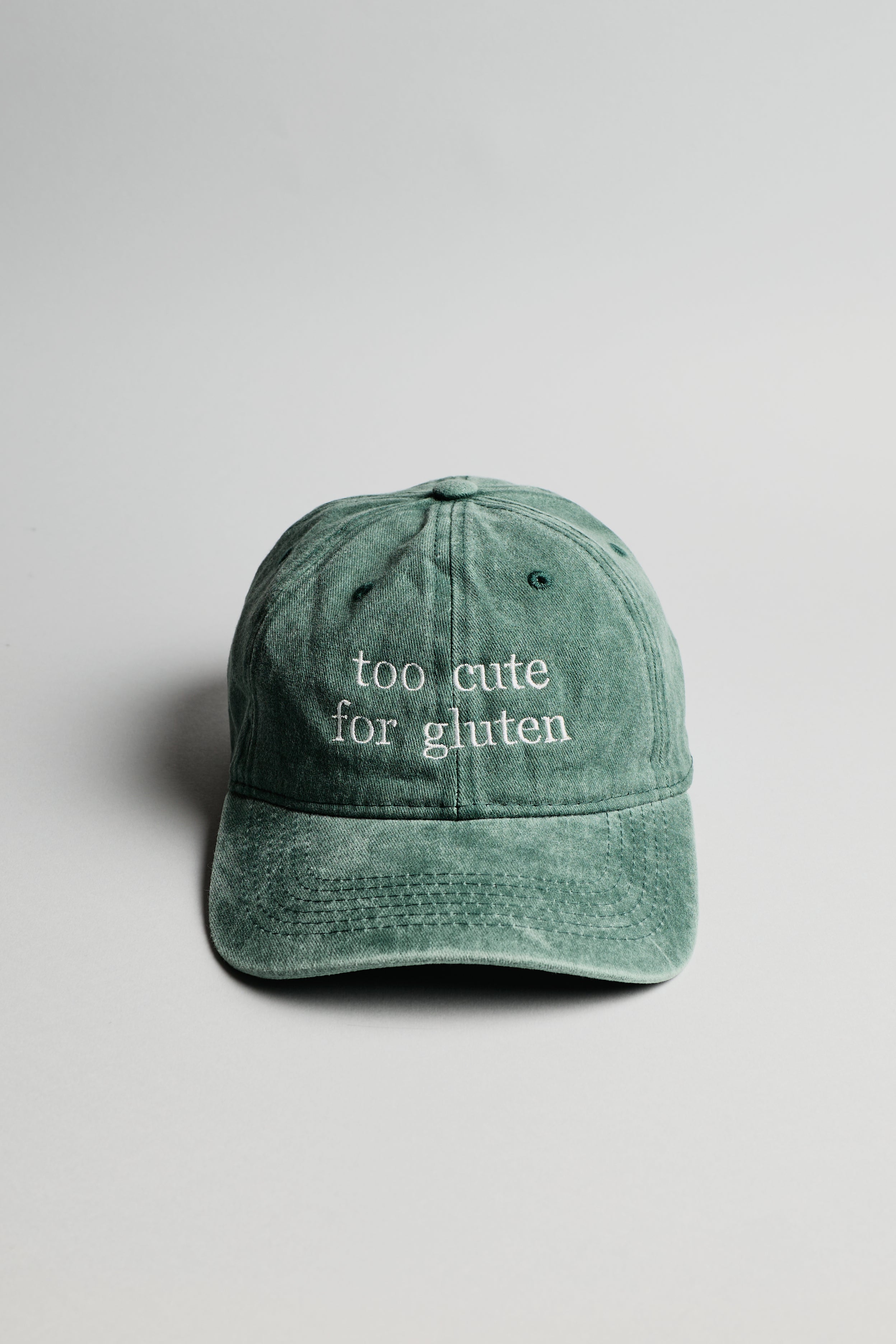 Zelená kšiltovka s bílým nápisem "too cute for gluten"