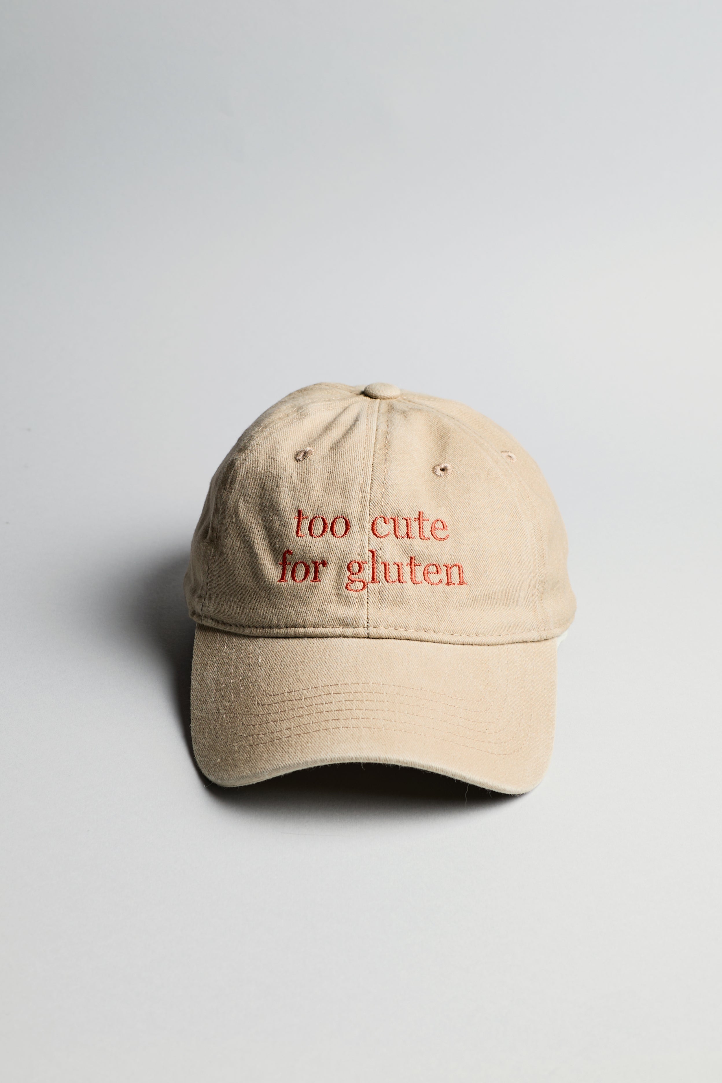 Béžová kšiltovka s červeným nápisem "too cute for gluten"