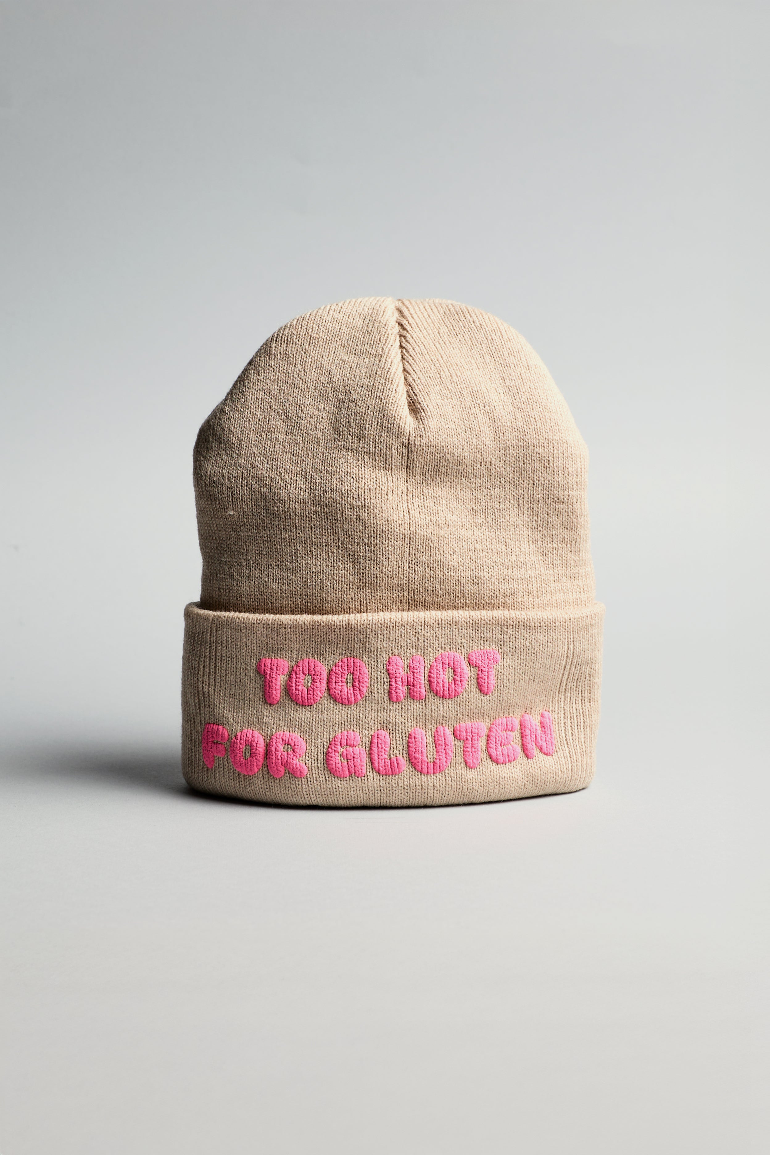 Béžová čepice s růžovým nápisem "too hot for gluten"